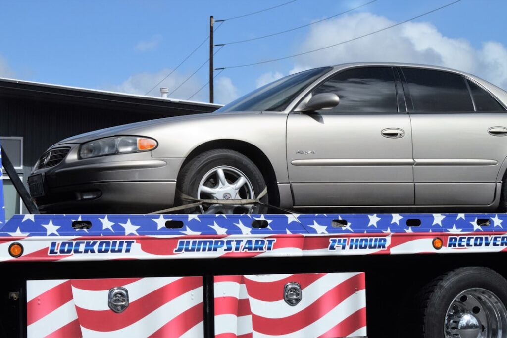 a-flatbed-tow-truck-with-a-silver-car-on-it-deusdsnhgga